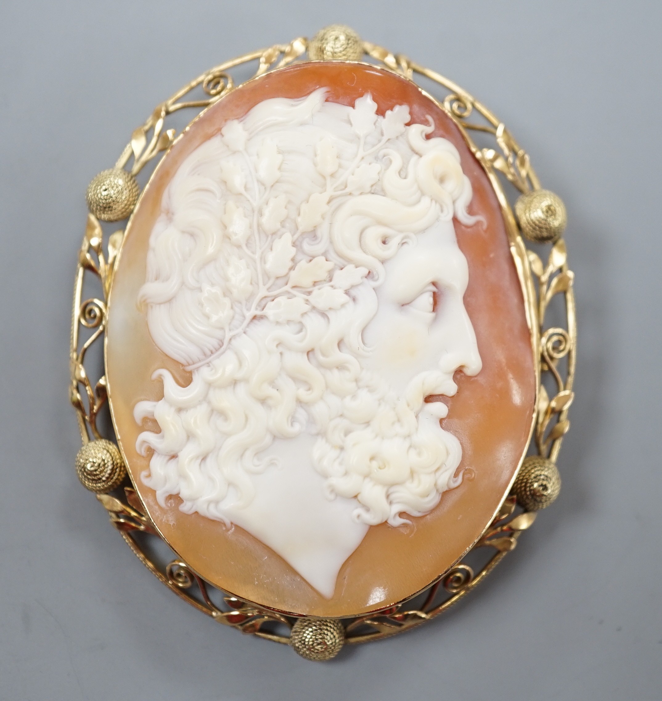 After the antique- A yellow metal mounted oval cameo shell brooch, carved with the head of a Zeus to sinister, 62mm, gross weight 20.7 grams.